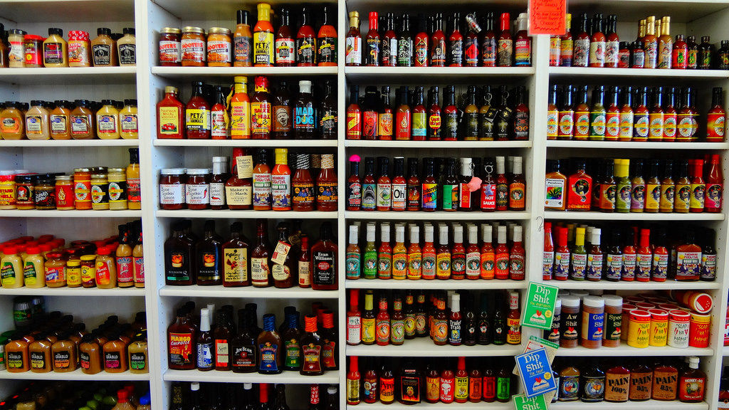 Wall of hot sauces on shelves at a shop