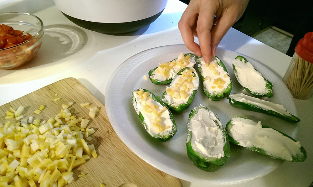 Adding cheese to the jalapeno poppers
